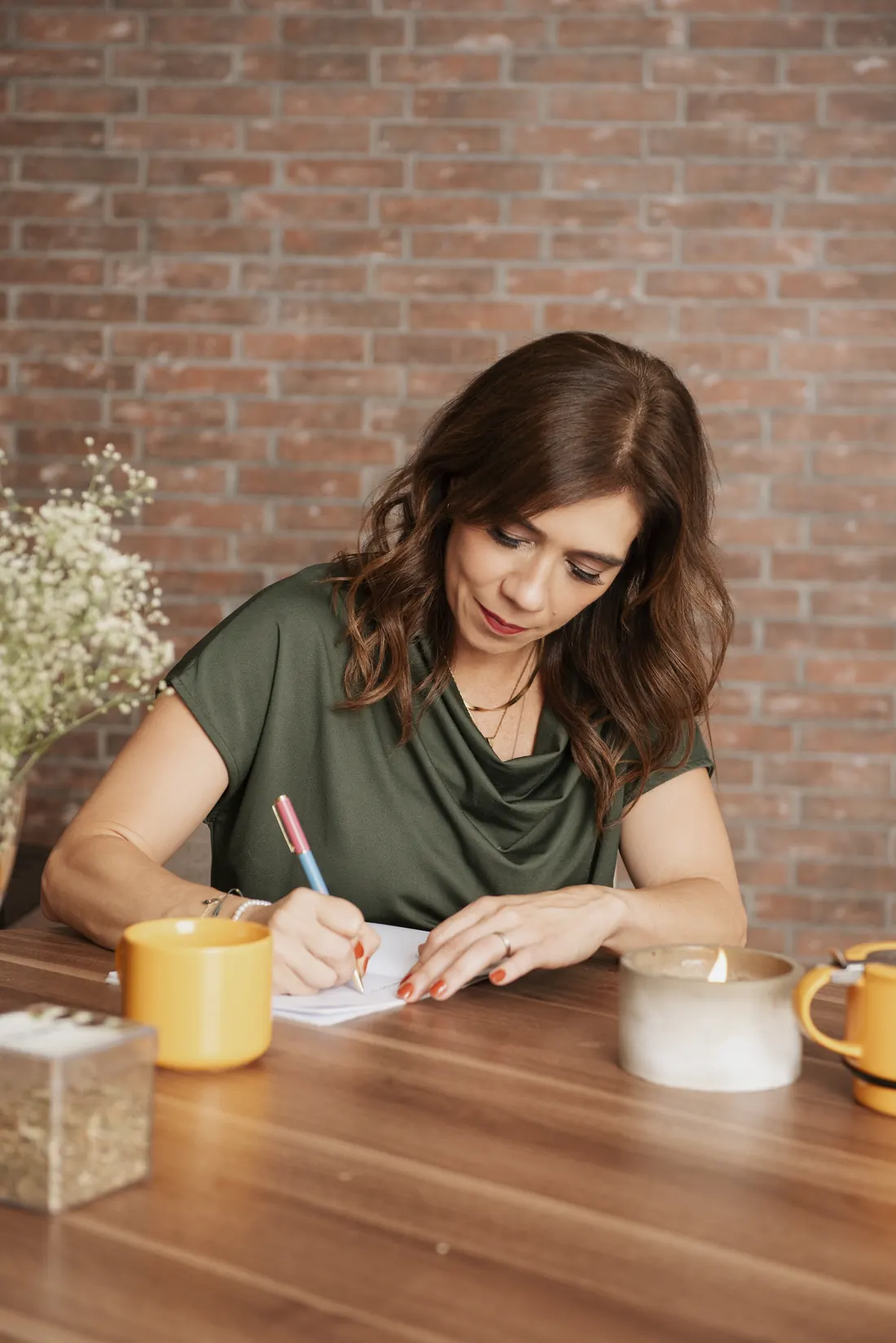 Cici escribiendo en su journal junto a una taza de té