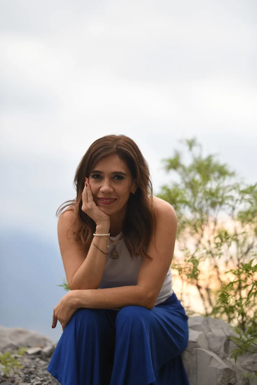 Cici sentada en una roca en el cerro
